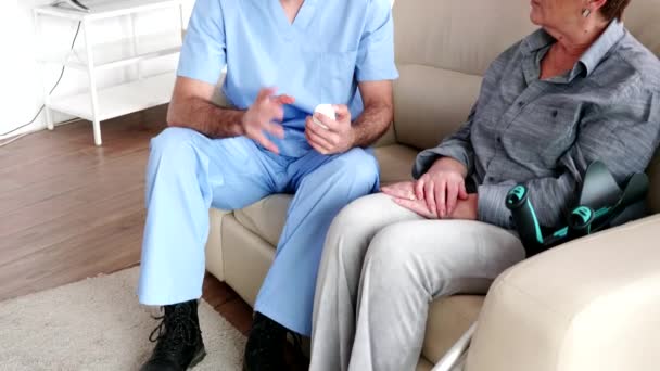 Doctor assistant on the couch with elderly woman - Video