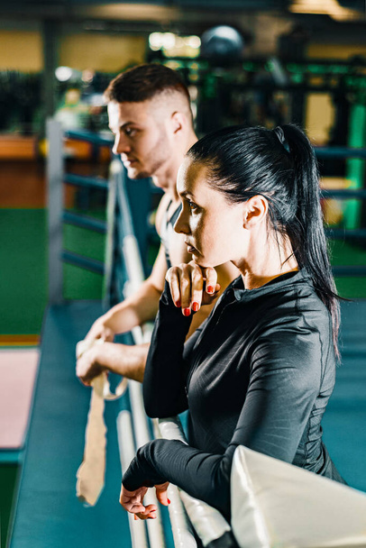 deep in thought beautiful girl and a guy stand in the boxing ring in the gym - Photo, Image