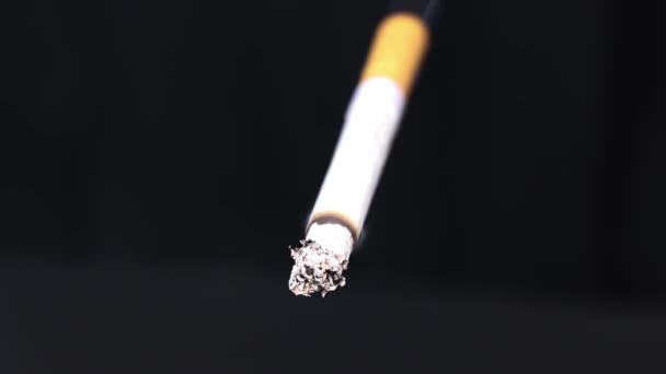 Schwelende Zigarette auf schwarzem Hintergrund. Rauch aus einer Zigarette. Zeitlupe. Das Konzept eines gesunden Lebensstils. - Filmmaterial, Video