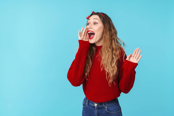 Image of cheerful young woman in headband screaming and looking aside isolated over blue background - Photo, Image