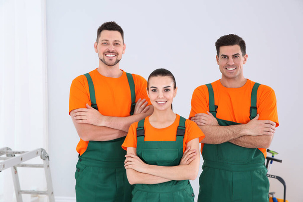 Team of professional janitors in uniform indoors. Cleaning service - Foto, afbeelding