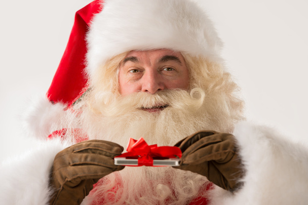 Άγιος Βασίλης, κρατώντας την συσκευή δώρο στα χέρια του - Φωτογραφία, εικόνα