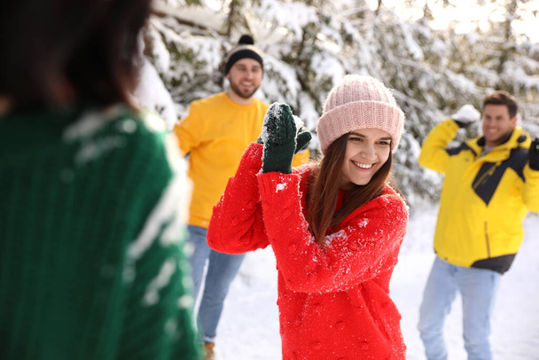 Happy friends playing snowballs outdoors. Winter vacation - Fotografie, Obrázek