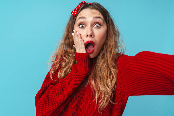Image of young blonde woman expressing surprise and taking selfie photo isolated over blue background - Fotoğraf, Görsel