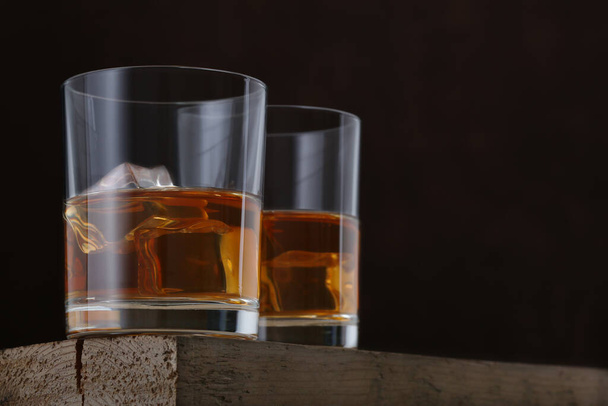 Dwie szklanki whisky na drewnianym stole. Zbliżenie - Zdjęcie, obraz