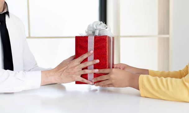 Young men hold gift boxes to give to young women, Give gifts to your loved ones on this important holiday season ,New Year's Day, Chrismas Day, Give a gift concept. - Photo, Image
