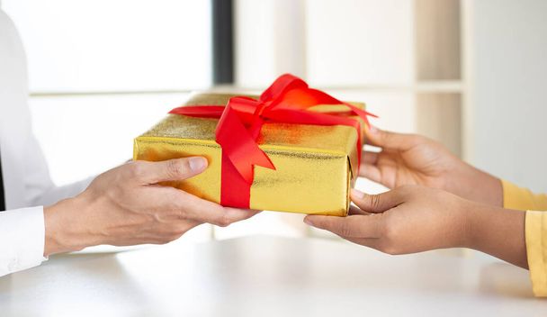 Молодые люди держат подарочные коробки, чтобы дать молодым женщинам, дарить подарки своим близким в этот важный праздничный сезон, Новый год, Рождество день, дать концепцию подарка
. - Фото, изображение