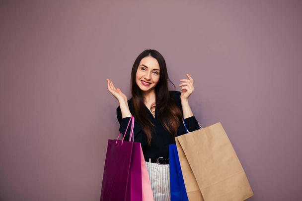 Black Friday sale concept for the store. Shopping woman in sunglasses holding bag isolated on dark background. - Fotoğraf, Görsel
