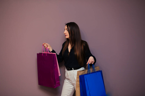 Portrait of happy brunette with paperbags after shopping. - Foto, imagen