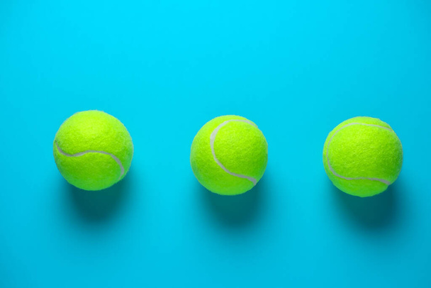 three tennis balls on a bright blue background - Fotografie, Obrázek
