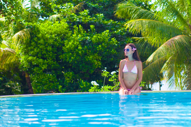 Beautiful young woman enjoying the luxury quiet swimmingpool - Foto, Imagem