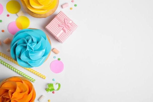 Flat lay composition with colorful birthday cupcakes on white background. Space for text - 写真・画像