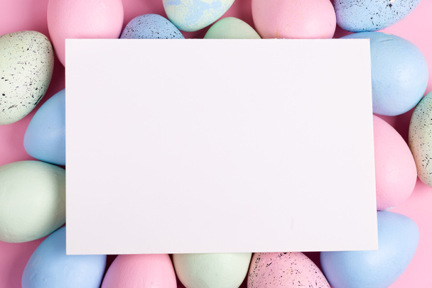 Ευτυχισμένο Πάσχα ευχετήρια κάρτα από χειροποίητα βαμμένα πολύχρωμα αυγά και φύλλο χαρτιού για συγχαρητήρια κείμενο. - Φωτογραφία, εικόνα