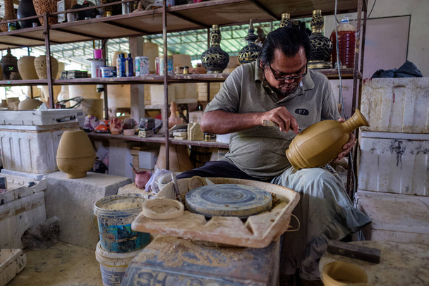 Un artisan local fait une démonstration sur la fabrication d'un bocal traditionnel en argile appelé Labu Sayong ou Essence Jar of Sayong à Kuala Kangsar, Perak, Malaisie. Concept de poterie
. - Photo, image