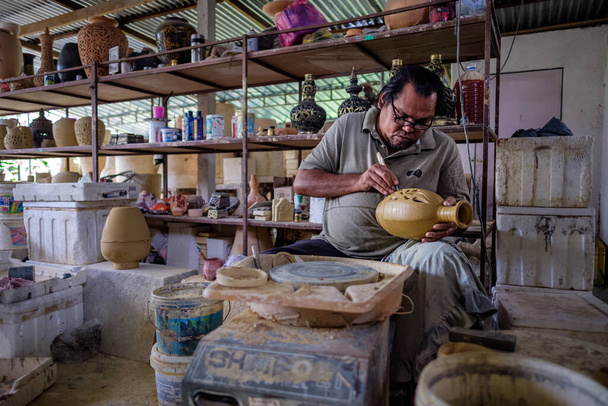 Místní řemeslník demonstruje na výrobu tradiční hliněné sklenice Labu Sayong nebo Essence Jar Sayong v Kuala Kangsar, Perak, Malajsie. Koncept hrnčíře. - Fotografie, Obrázek