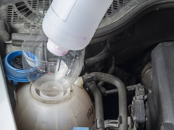 Перевірка рівня охолоджуючої рідини радіатора автомобіля і додавання Liqiud
. - Фото, зображення
