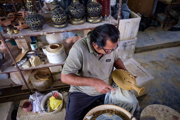 Artesano local demuestra en la fabricación de tarro de arcilla tradicional llamado Labu Sayong o Essence Jar de Sayong en Kuala Kangsar, Perak, Malasia. Concepto de cerámica
. - Foto, imagen