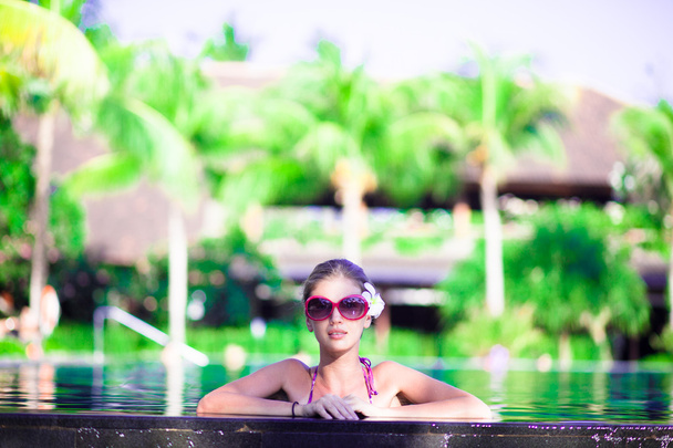 Portrait of young attractive smiling woman in luxury pool - Fotó, kép