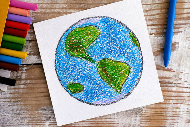Disegno a mano Pianeta Terra con pastelli di cera su sfondo di legno
. - Foto, immagini