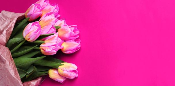 Рожеві тюльпани лежать на рожевому фоні. День матері, річниця, 8 березня - Міжнародний жіночий день, День святого Валентина. Банер, вітальня, місце для тексту. Вид згори.. - Фото, зображення