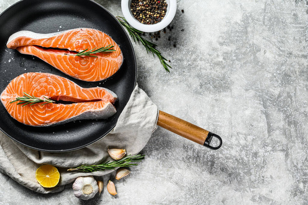 Raw trout steak in a frying pan. Healthy seafood. Gray background. Top view. Space for text. - Fotoğraf, Görsel