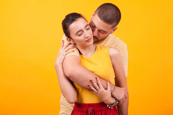 Girlfriend holding eyes closed while boyfriend hugs her from behind - Photo, Image