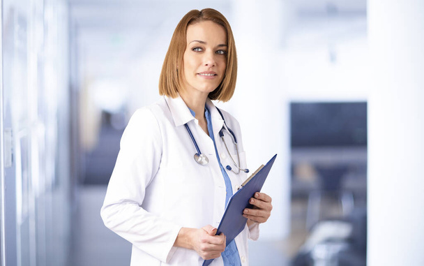 Shot of middle aged female doctor holding clipboard - Φωτογραφία, εικόνα