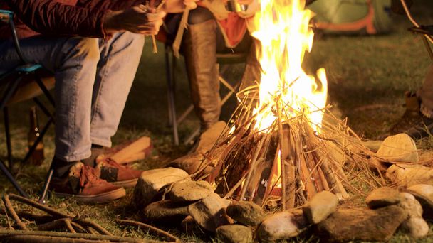 寒い夜に彼の友人のためのキャンプの火を作る男のハンドヘルド映像 - 写真・画像