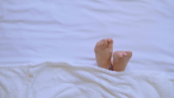 top view female legs under a white blanket - Video
