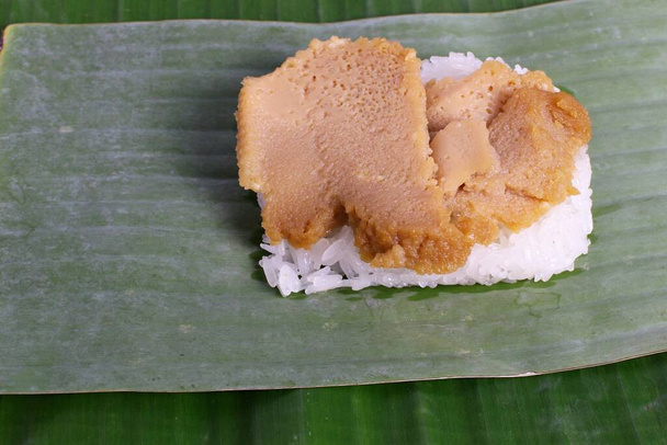 Dolce tailandese, riso al vapore appiccicoso, crema pasticcera avvolta in foglie di banana
. - Foto, immagini