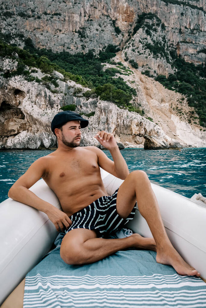 Сардиния Оросей побережье Италии, парень на отдыхе на острове Сардиния на лодке поездка на все белые галечные пляжи некоторые из самых красивых пляжей в Европе
  - Фото, изображение