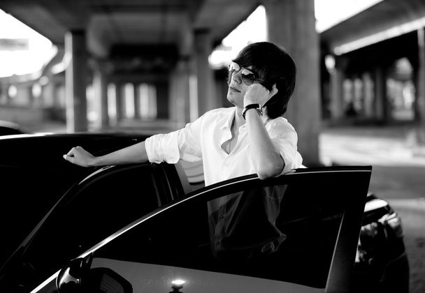 όμορφος επιχειρηματίας που μιλάει στο τηλέφωνο κοντά με το αυτοκίνητο - Φωτογραφία, εικόνα