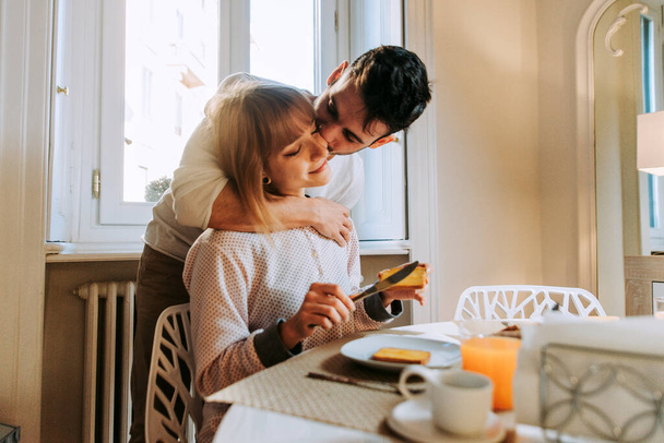 Two young adults at home - Beautiful couple of lovers having breakfast in the morning - 写真・画像