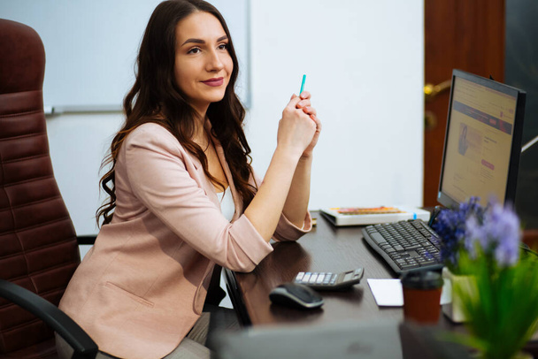 young business woman reading sitting at the desk on office background. - Photo, Image
