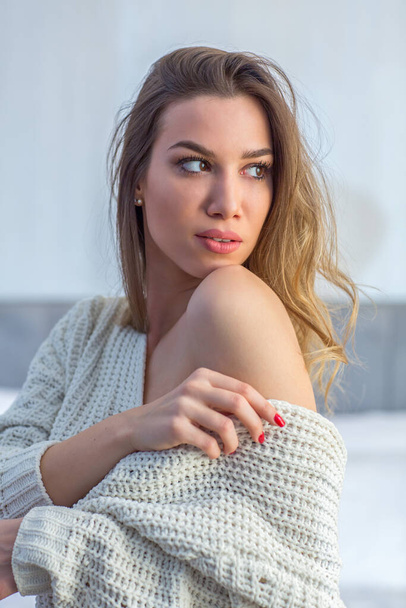Sexy young woman in sweater posing in hotel room - Fotoğraf, Görsel