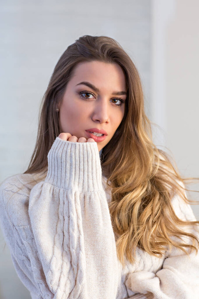 Sexy young woman in sweater posing in hotel room - Φωτογραφία, εικόνα