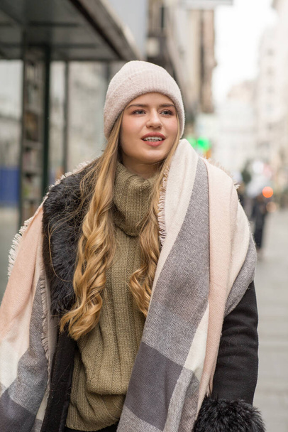 Beautiful young woman in winter autumn outfit walking in the city street - Fotó, kép