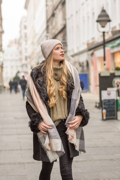 Beautiful young woman in winter autumn outfit walking in the city street - Foto, Imagen