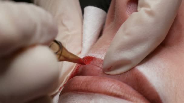 Мікроблокування татуювання губ спеціальним забарвленням червоного пігменту, який виправляє колір губ у клініці косметології. Перманентна процедура макіяжу губ нанесення пігментного макіяжу на губи за допомогою татуювальної машини
 - Кадри, відео