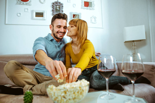Two young adults at home - Beautiful couple relaxing and watching a movie at tv - 写真・画像