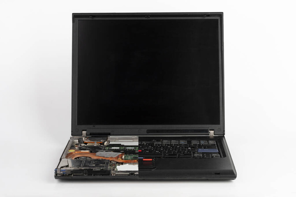 Старий ноутбук, видалена половина клавіатури на білому фоні, видимий помаранчевий куп вентилятор з тепловою раковиною
 . - Фото, зображення