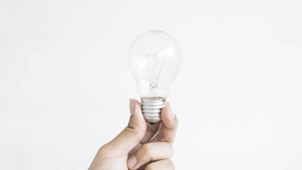 Closeup of hand holding light bulb, isolated on white background - Photo, image