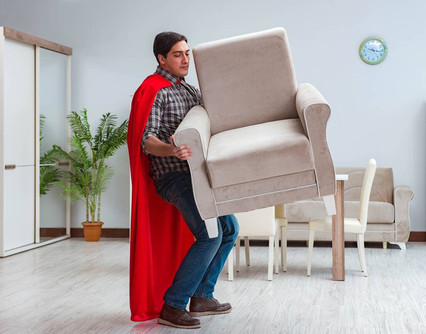 Super hero moving furniture at home - 写真・画像