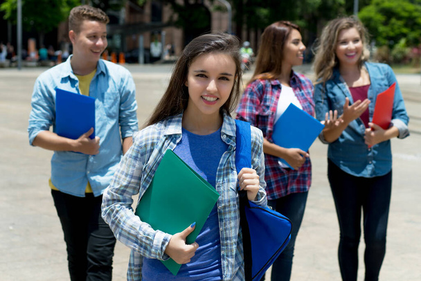 Молода біла студентка з групою молодих людей влітку в місті
 - Фото, зображення