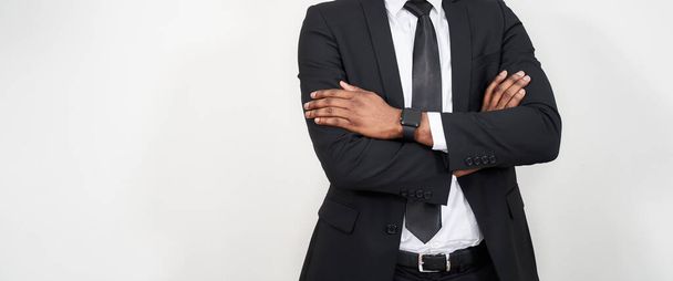 Cropped portrait of successful african man with arms crossed over grey background with copy space - Foto, Imagem