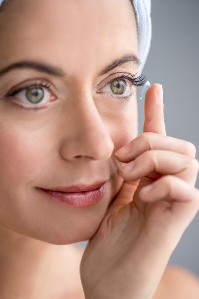 woman in her forties inserting contact lenses - Foto, Bild