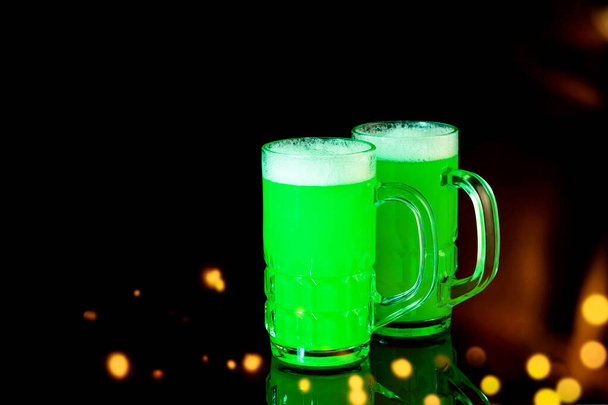 Egy korsó zöld sör a tükröződő fekete háttéren. Szent Patrik napját ünnepeljük. Fények, szép bokeh, művészet design.  - Fotó, kép