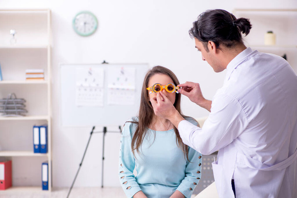 Mujer joven visitando médico oculista masculino - Foto, Imagen