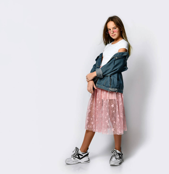 Young smiling teen girl in stylish casual clothes, sneakers and pink sunglasses standing and looking at camera - Fotoğraf, Görsel