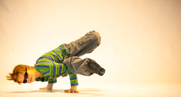 little boy in a unique dance pose, difficult acrobatic position, cheerful boy, exceptional child - Photo, Image